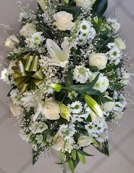 Cuscino funebere con fiori misti tonalità del bianco. Lunghezza circa 100 cm
