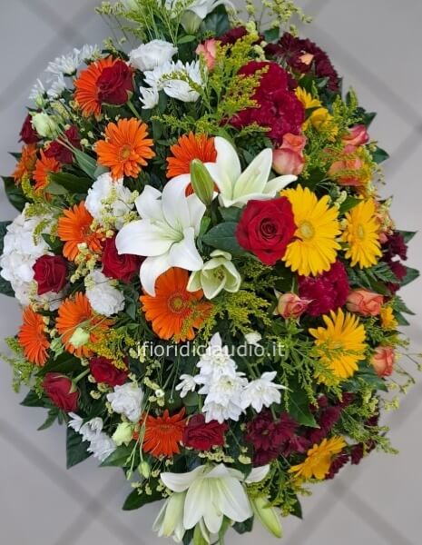 Cuscino funebere con fiori misti. Dai toni Caldi. Lunghezza circa 100 cm